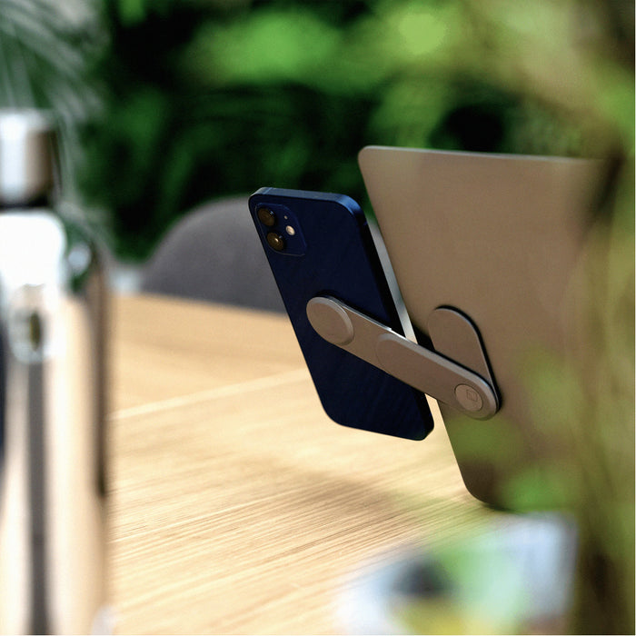 EDGE® Full Kit - Productivity magnetic kit - EDGE® Full Kit - Productivity magnetic kit - Carrara White - Basalt grey magnetic phone mount holding smartphone on wooden desk next to laptop and silver bottle. - Rolling Square EDGE® Full Kit - Productivity magnetic kit - Carrara White - Basalt grey magnetic phone mount holding smartphone on wooden desk next to laptop and silver bottle. - Rolling Square