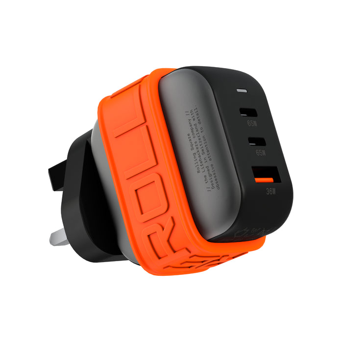 Essential GaN Charger - 65W power, 45% smaller - Essential GaN Charger - 65W power, 45% smaller - US - Compact black GaN charger with three USB ports and an orange silicone protective sleeve. - Rolling Square Essential GaN Charger - 65W power, 45% smaller - US - Compact black GaN charger with three USB ports and an orange silicone protective sleeve. - Rolling Square