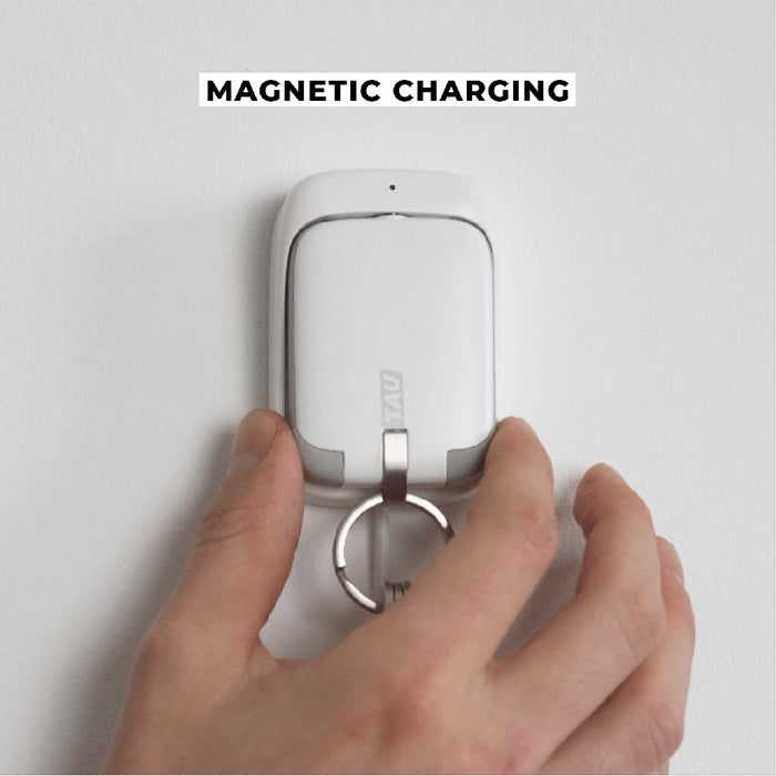 TAU® - Always-charged power bank - TAU® - Always-charged power bank - Charcoal Black - White compact power bank with keyring attached, held by hand, mounted on white wall for magnetic charging. - Rolling Square TAU® - Always-charged power bank - Charcoal Black - White compact power bank with keyring attached, held by hand, mounted on white wall for magnetic charging. - Rolling Square